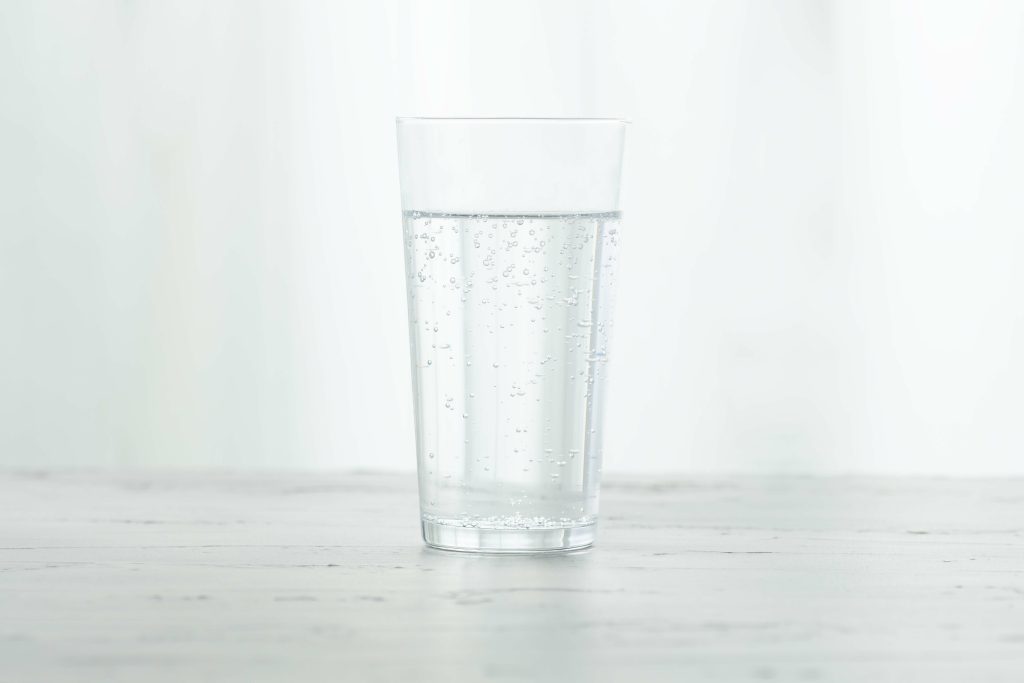 Verre d’eau posé sur une surface blanche