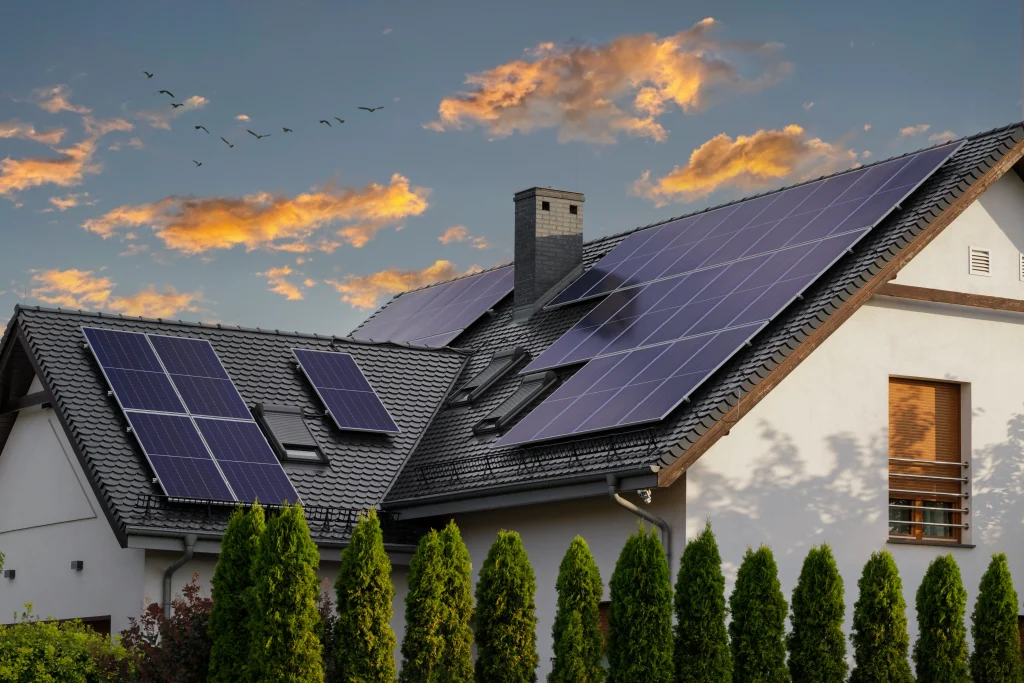 Maison équipée de panneaux solaires sur le toit au coucher du soleil